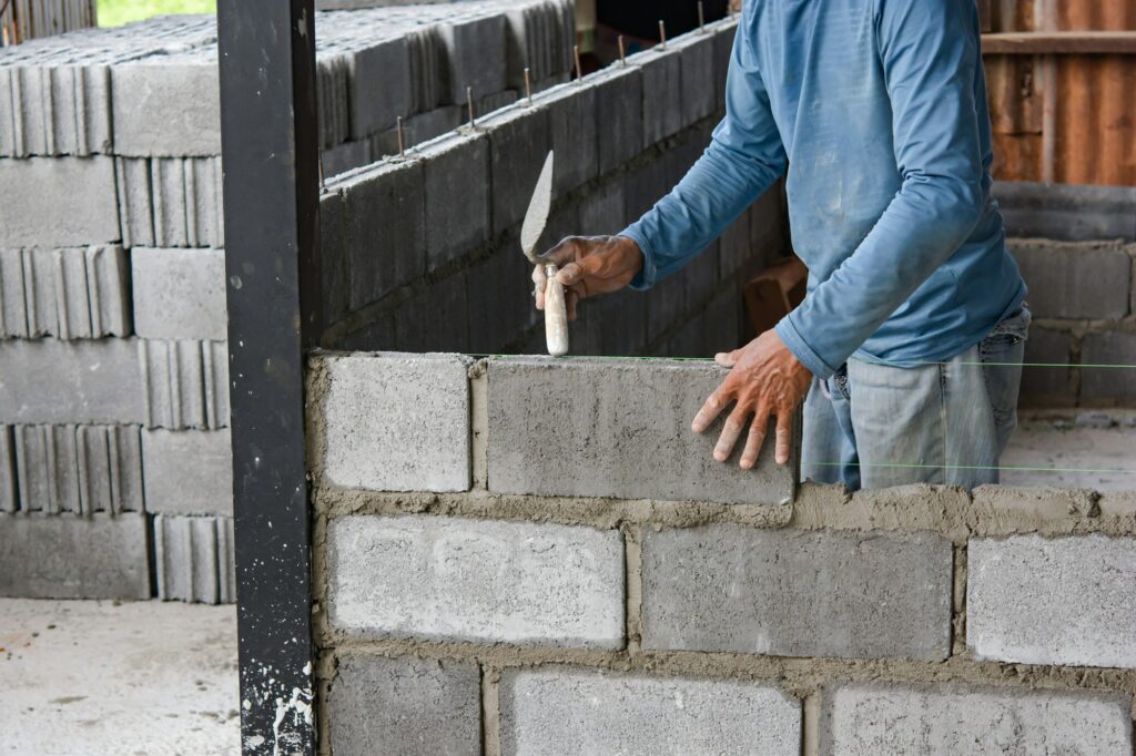 Bricklayer laying bricks on mortar