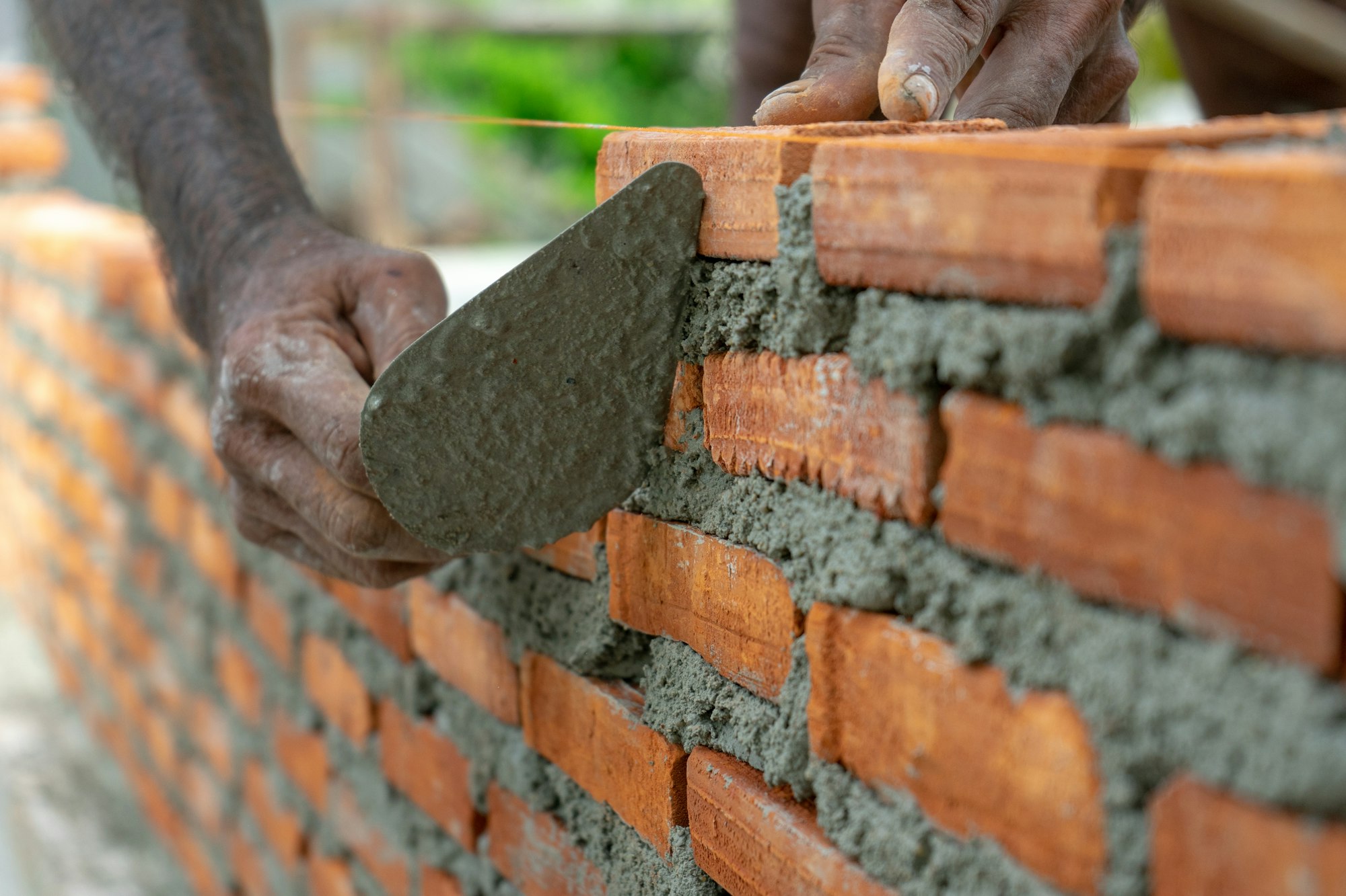 Worker uses trowel during installing the bricklayer wall